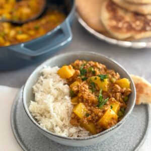 Close-up of creamy Thai coconut turkey potato curry garnished with cilantro.
