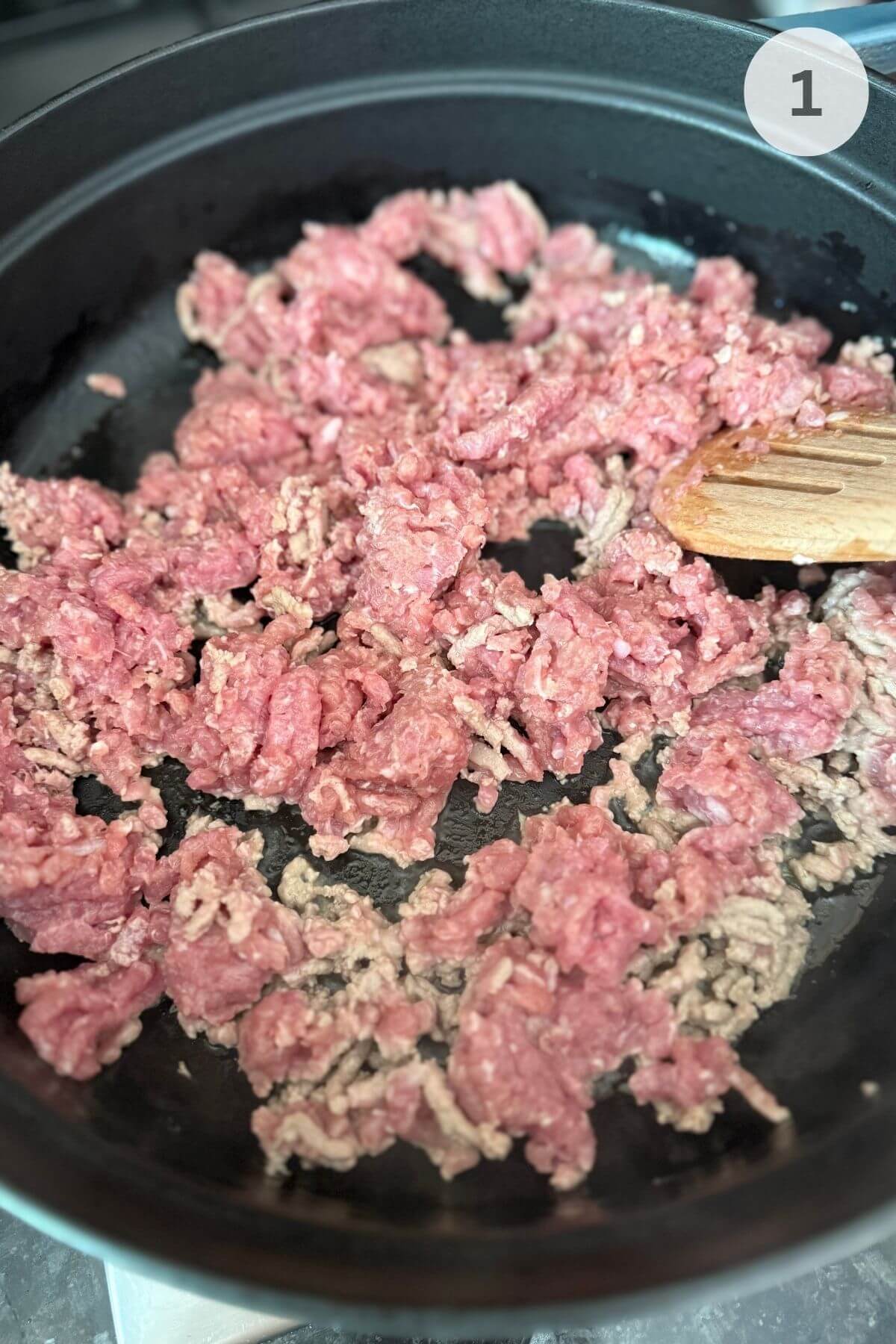 Cooked ground turkey browned in a pan with a light layer of oil over medium-high heat.