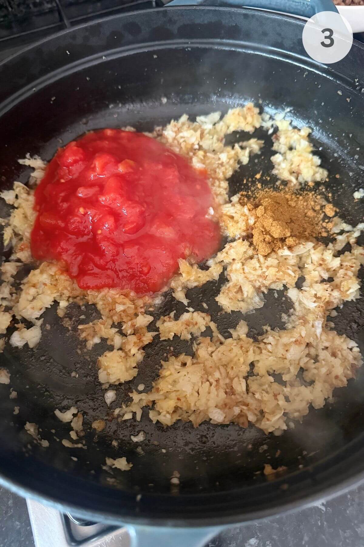 Softened onions in a pan with garlic, ginger, curry powder, and tomato paste just stirred in.
