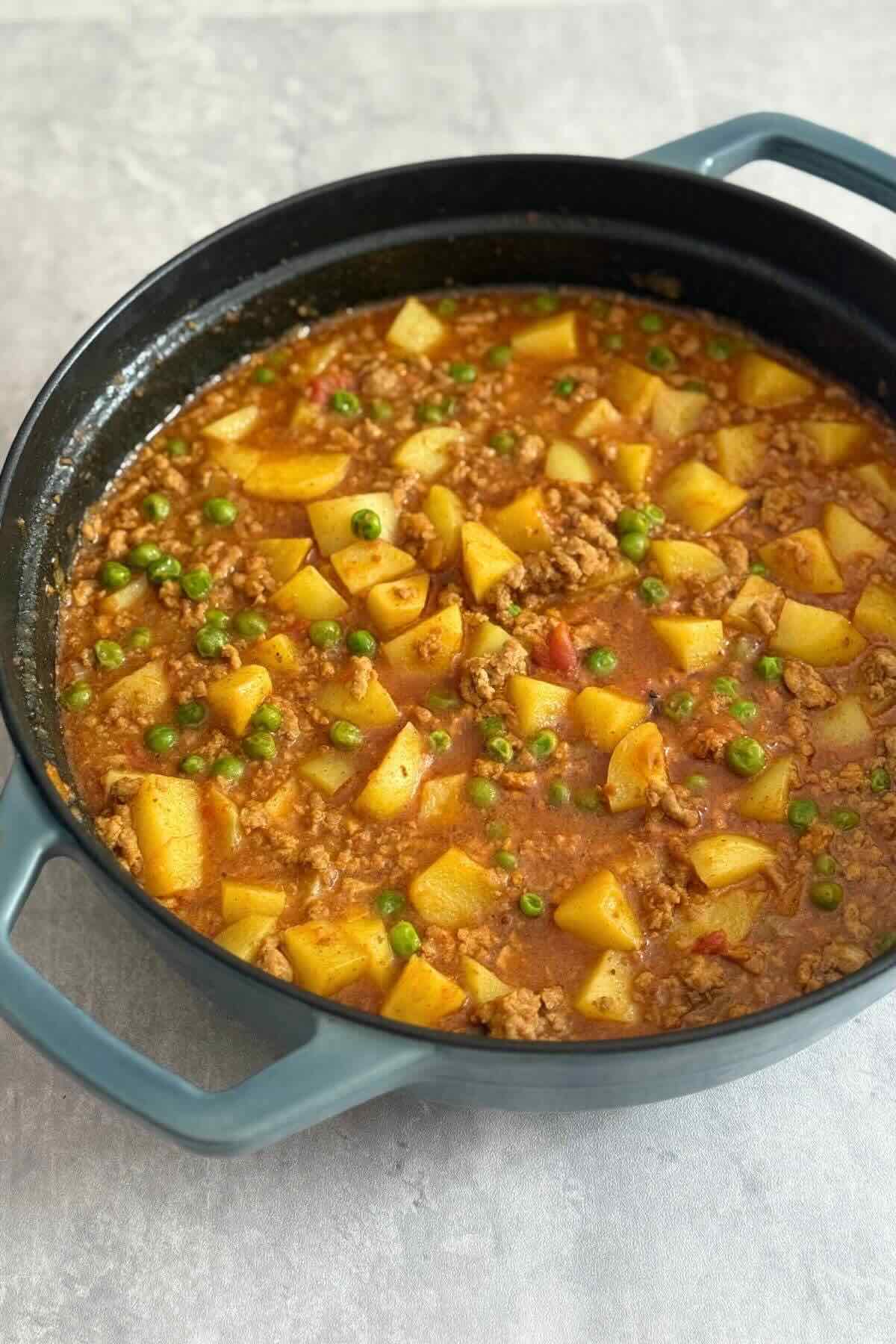 SImple thai curry with peas zucchini in a ceramic pan. 