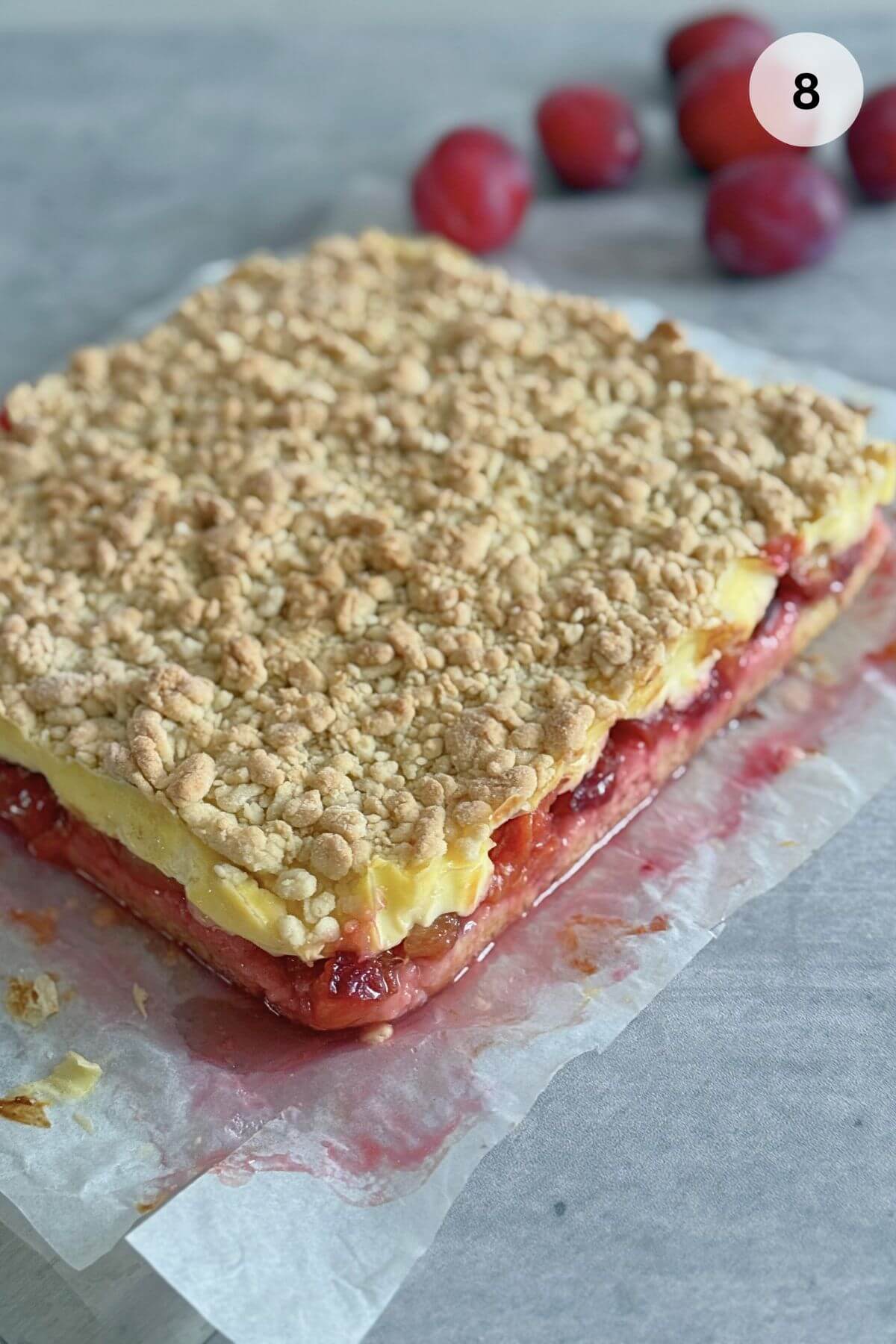 The final baked cake is removed from the oven, showing a crisp, golden top over the set pudding and fruit layers.