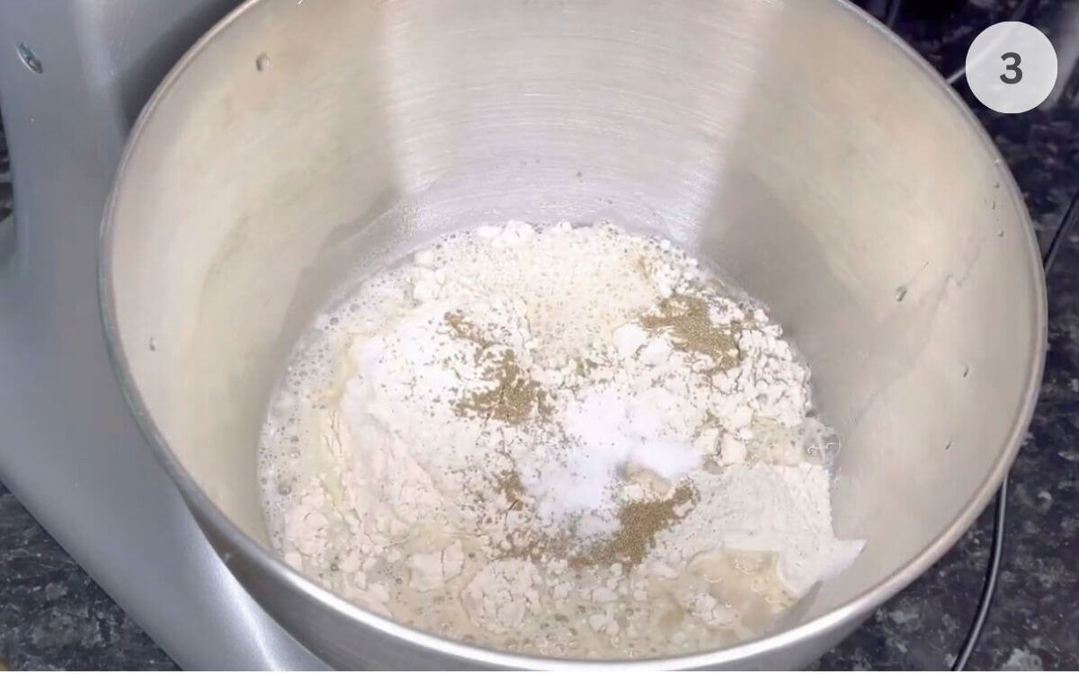 Lukewarm water poured over the flour and yeast in the same bowl.