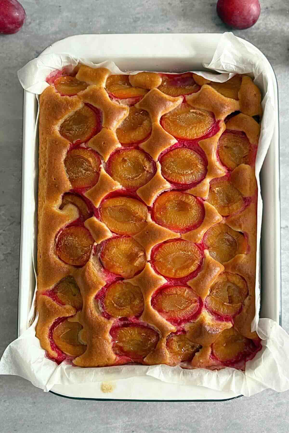 Golden brown kefir plum cake baked to perfection with juicy, caramelized plums on top.