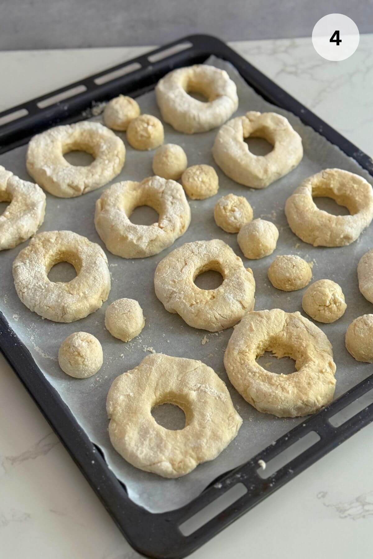 Shaping dough into balls with holes on a floured surface.