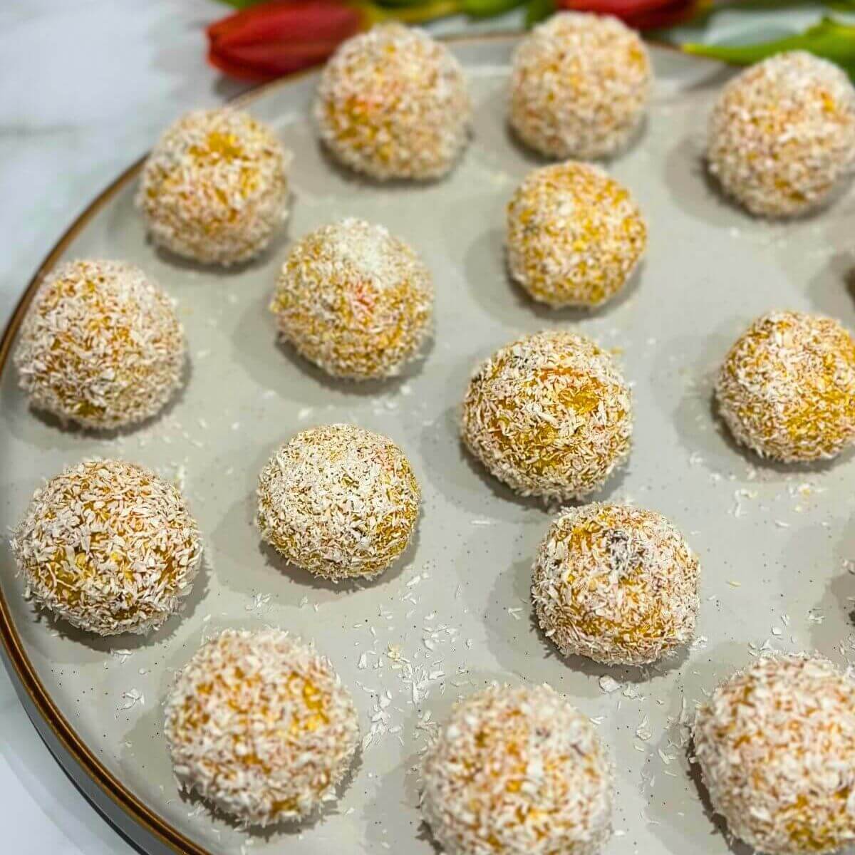 Vibrant carrot cake energy balls, rolled in coconut for a soft, chewy bite.