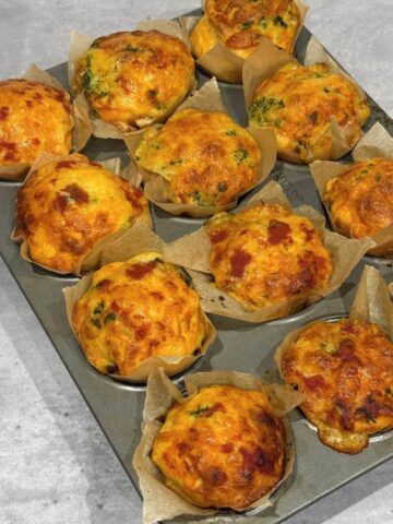 Garlic butter pizza cupcakes cooling, baked golden and topped with melted cheese.