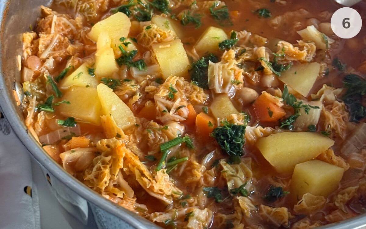Soup simmering with the lid on, then served warm with a sprinkle of parsley.
