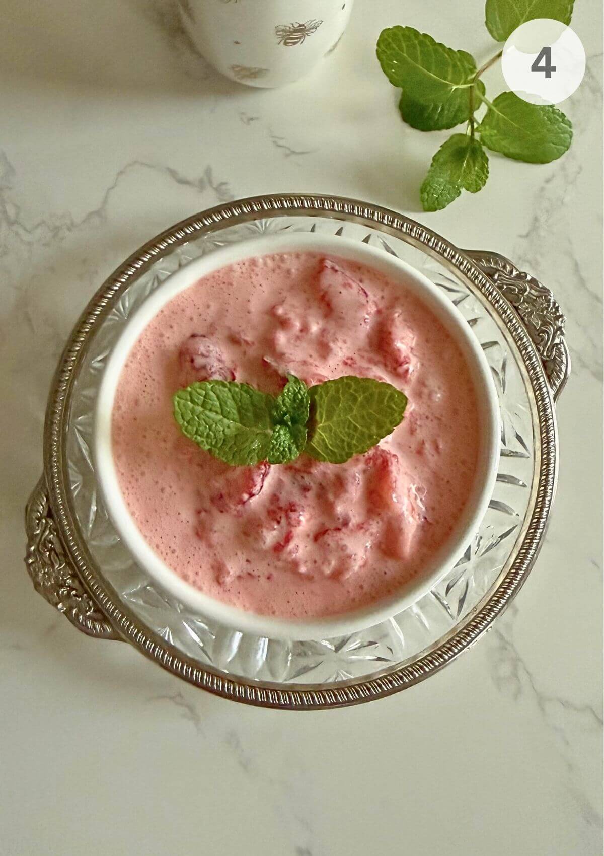 Strawberries and cream being mixed together to a thick, creamy pink dessert.