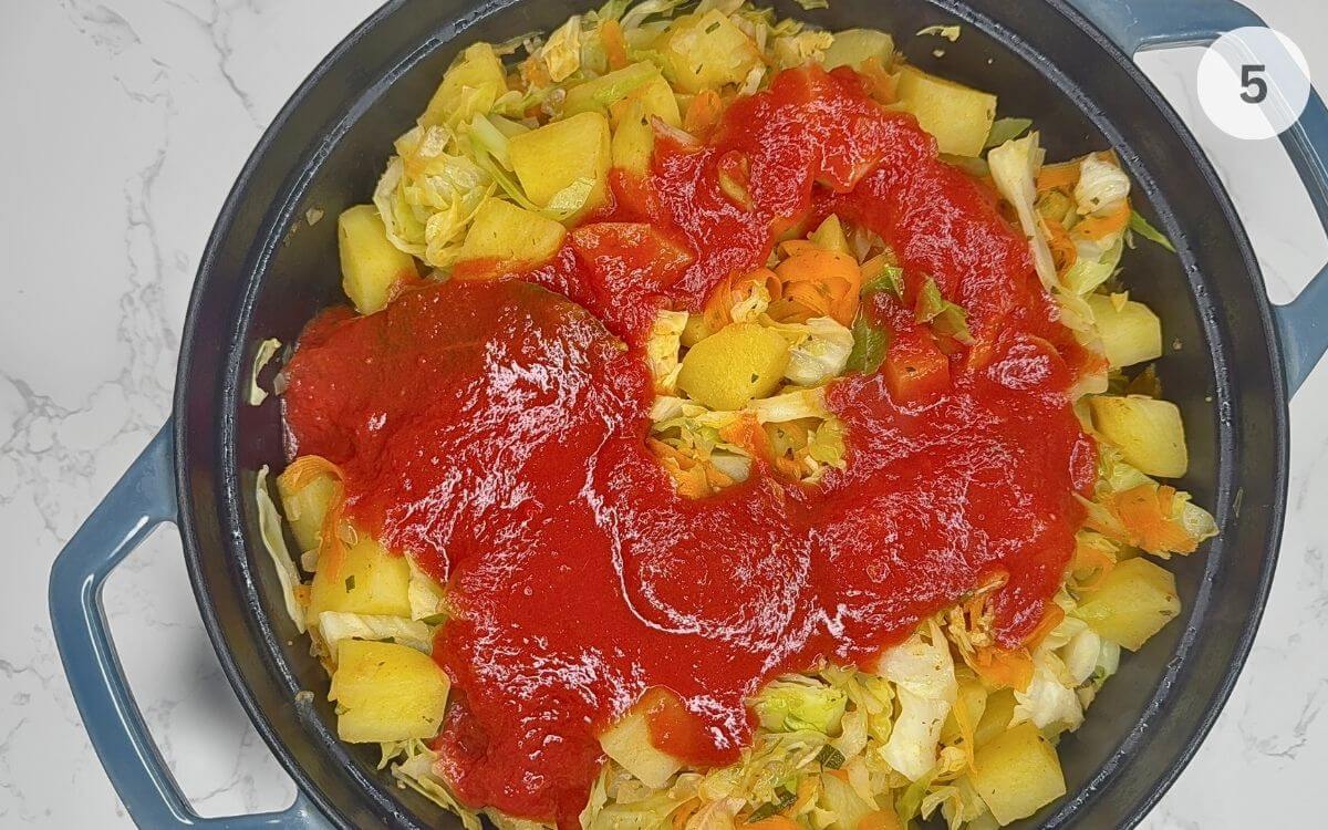 Tomato sauce stirred in, seasonings adjusted, stew simmering in the pan.