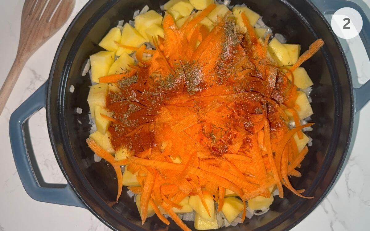 Potatoes and carrot strips stirred in with paprika, thyme, salt, and pepper.