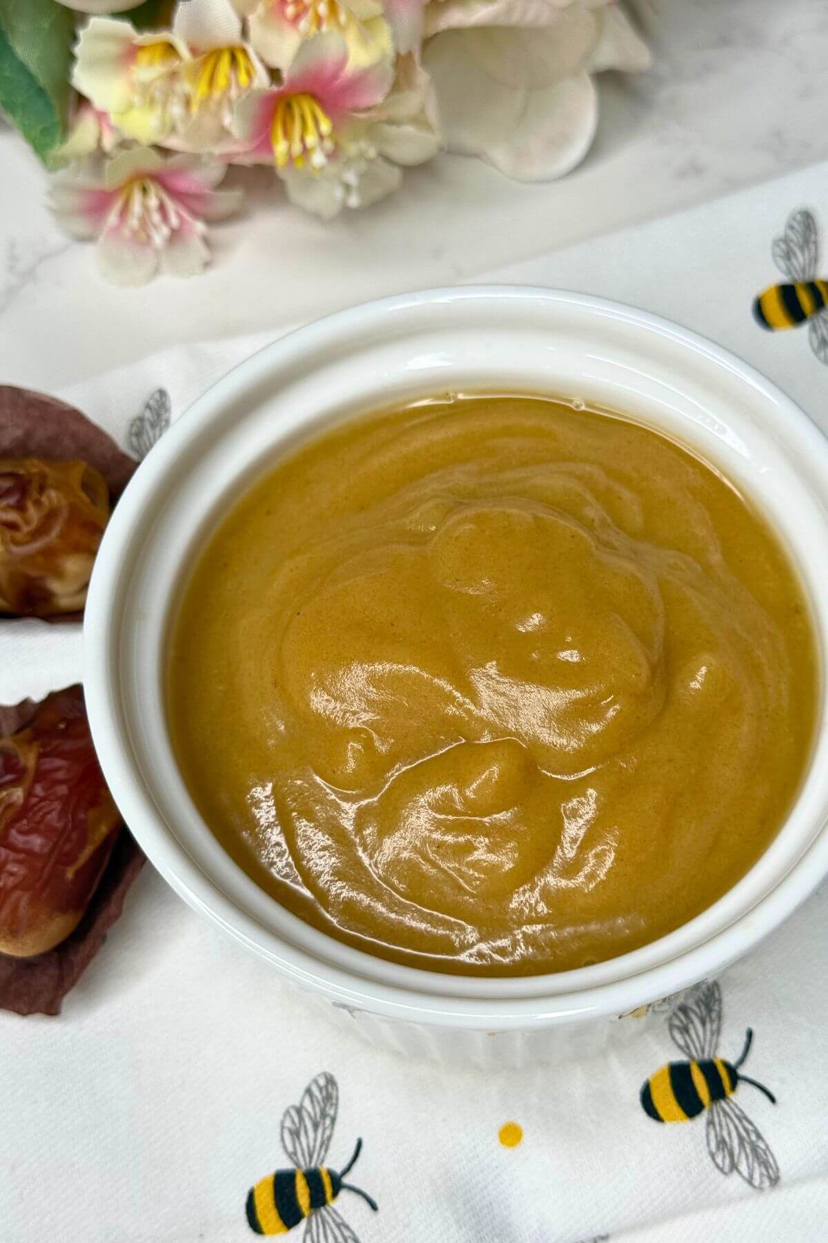 Easy 3-ingredient date caramel in a white ceramic bowl, made with coconut milk.