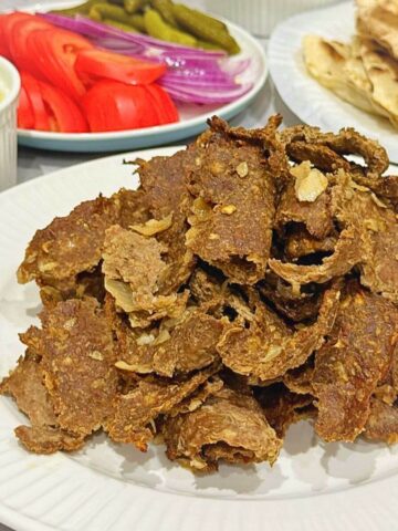 Slices of spiced, oven-baked viral doner kebab meat served in a warm pita with lettuce, tomatoes, and garlic yogurt sauce.