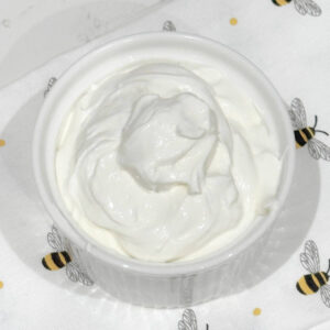 Creamy healthy cream cheese frosting made with Greek yogurt, no butter in a white ceramic dish.