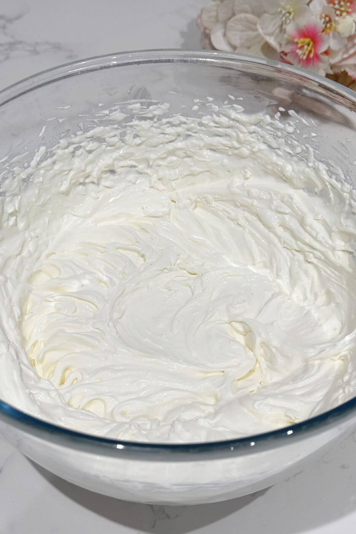 Electric mixer beating the yogurt cream cheese ingredients until the frosting is smooth and fluffy.