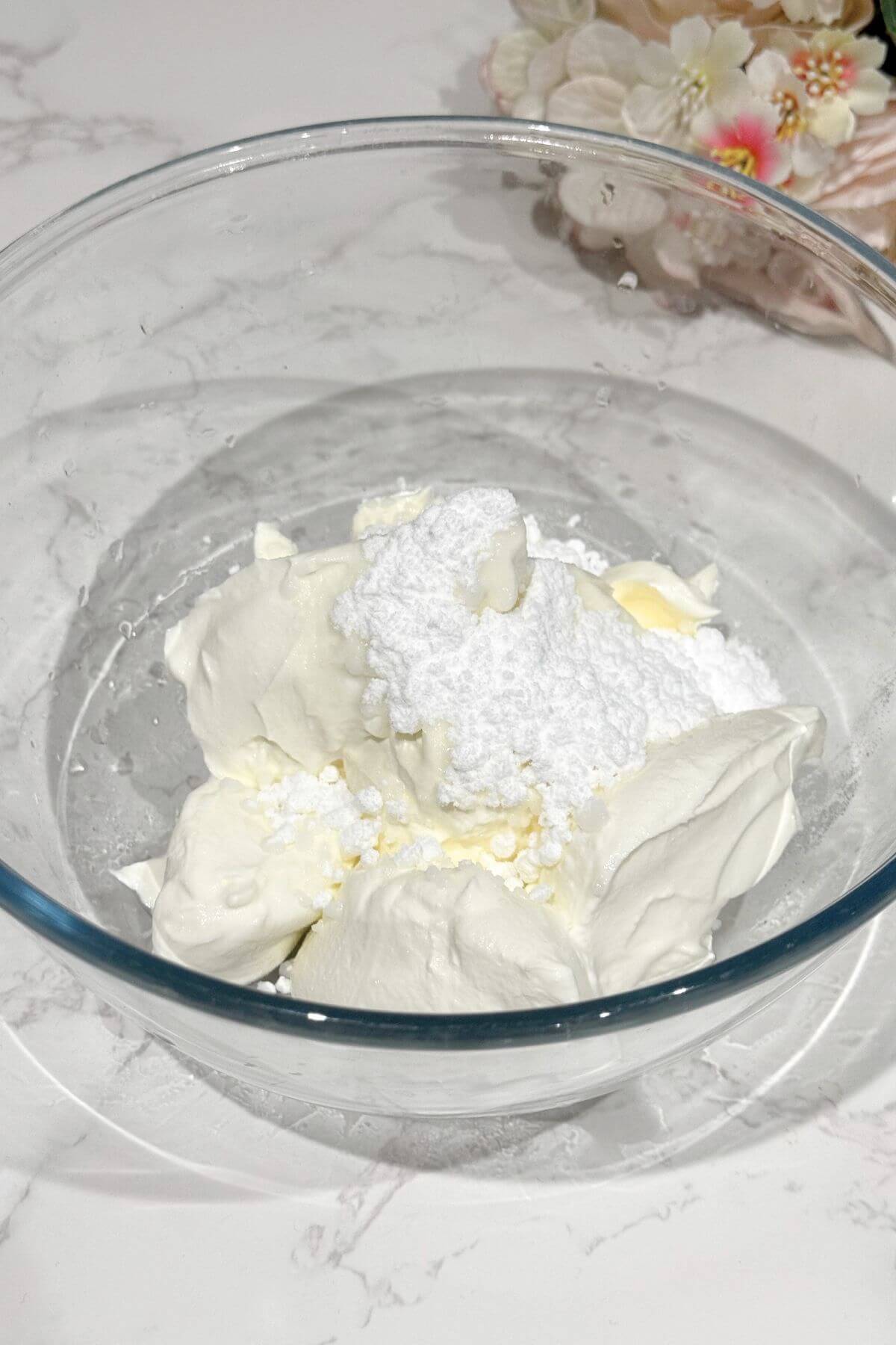 Cream cheese, Greek yogurt, sugar, and vanilla paste in a bowl, ready for the mixer.