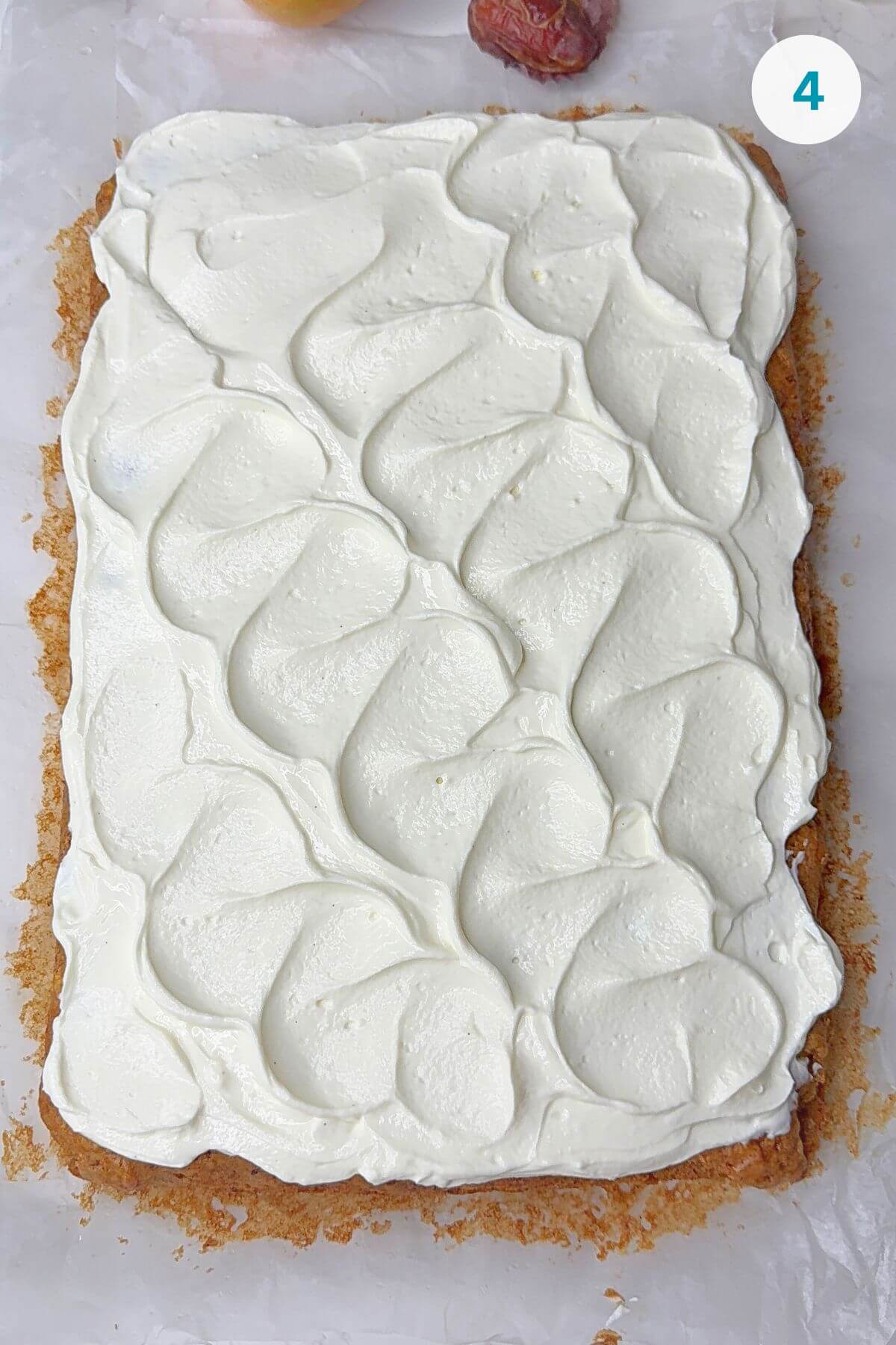 Cream cheese frosting spread evenly over the cooled cake with a simple pattern.