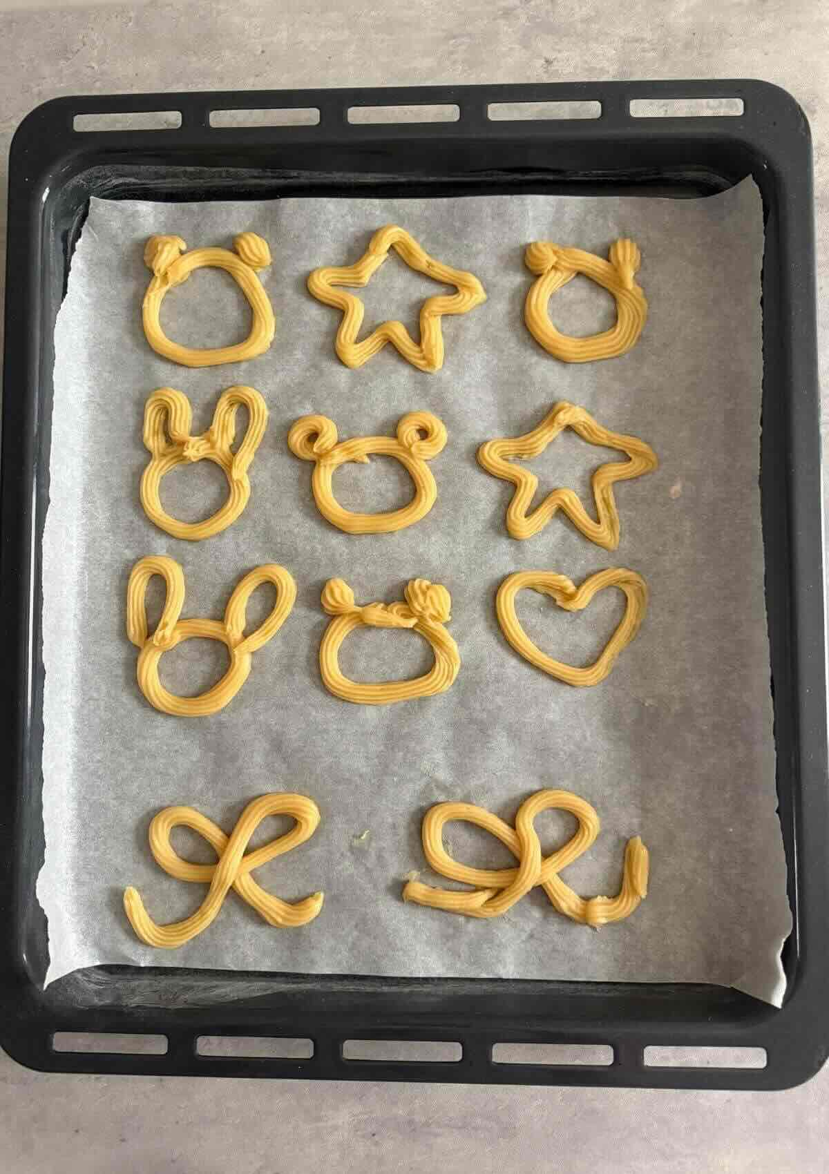 Homemade baked churros recipe dough piped as mini bears, stars, and bunnies, ready for the oven.