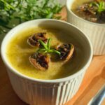 Homemade mushroom paté in a serving dish, topped with mushrooms and rosemary.