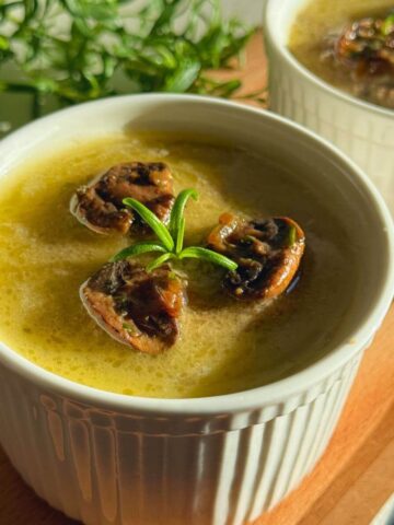 Homemade mushroom paté in a serving dish, topped with mushrooms and rosemary.