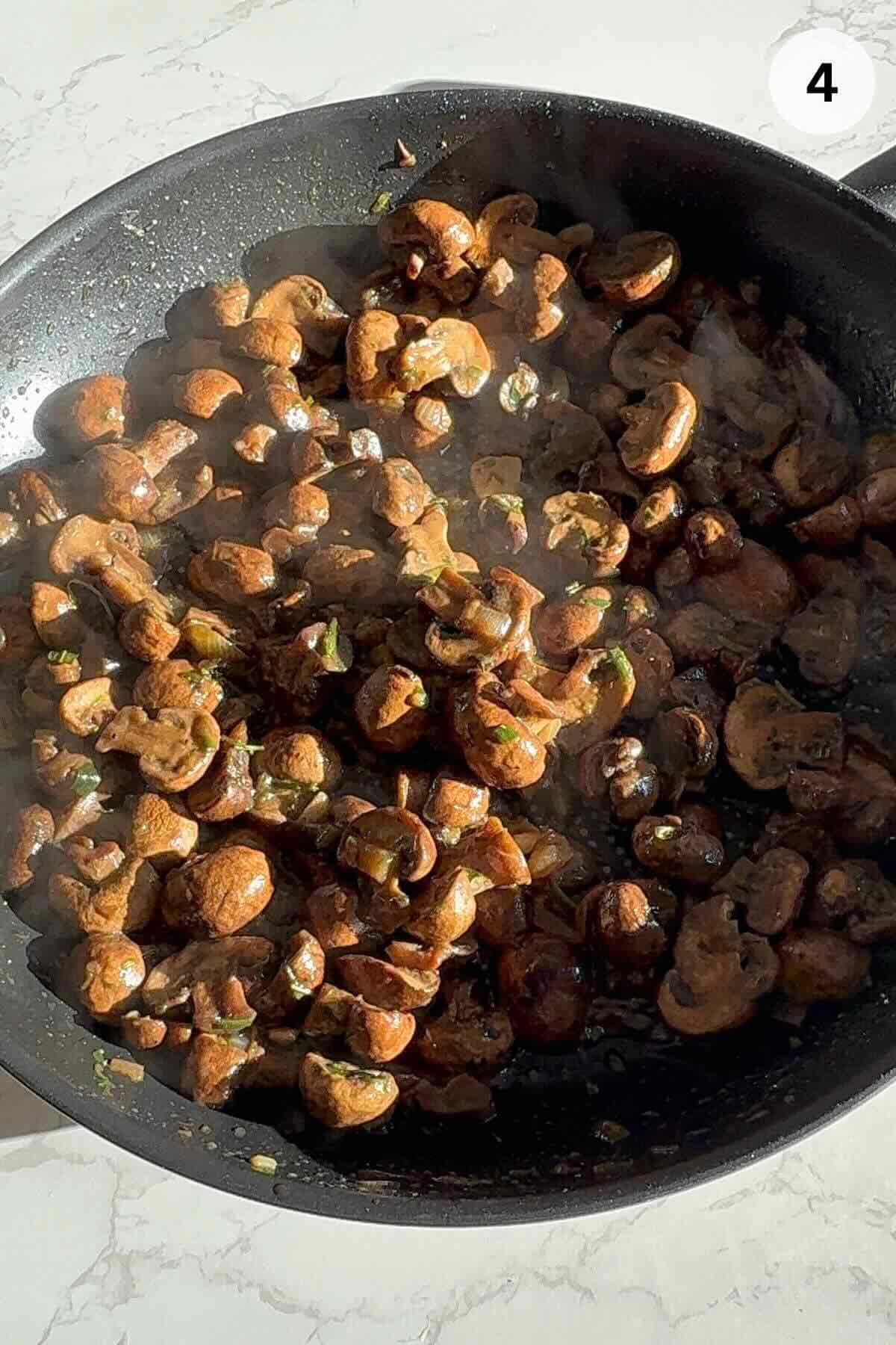 Cooked mushrooms in pan with liquid evaporated.