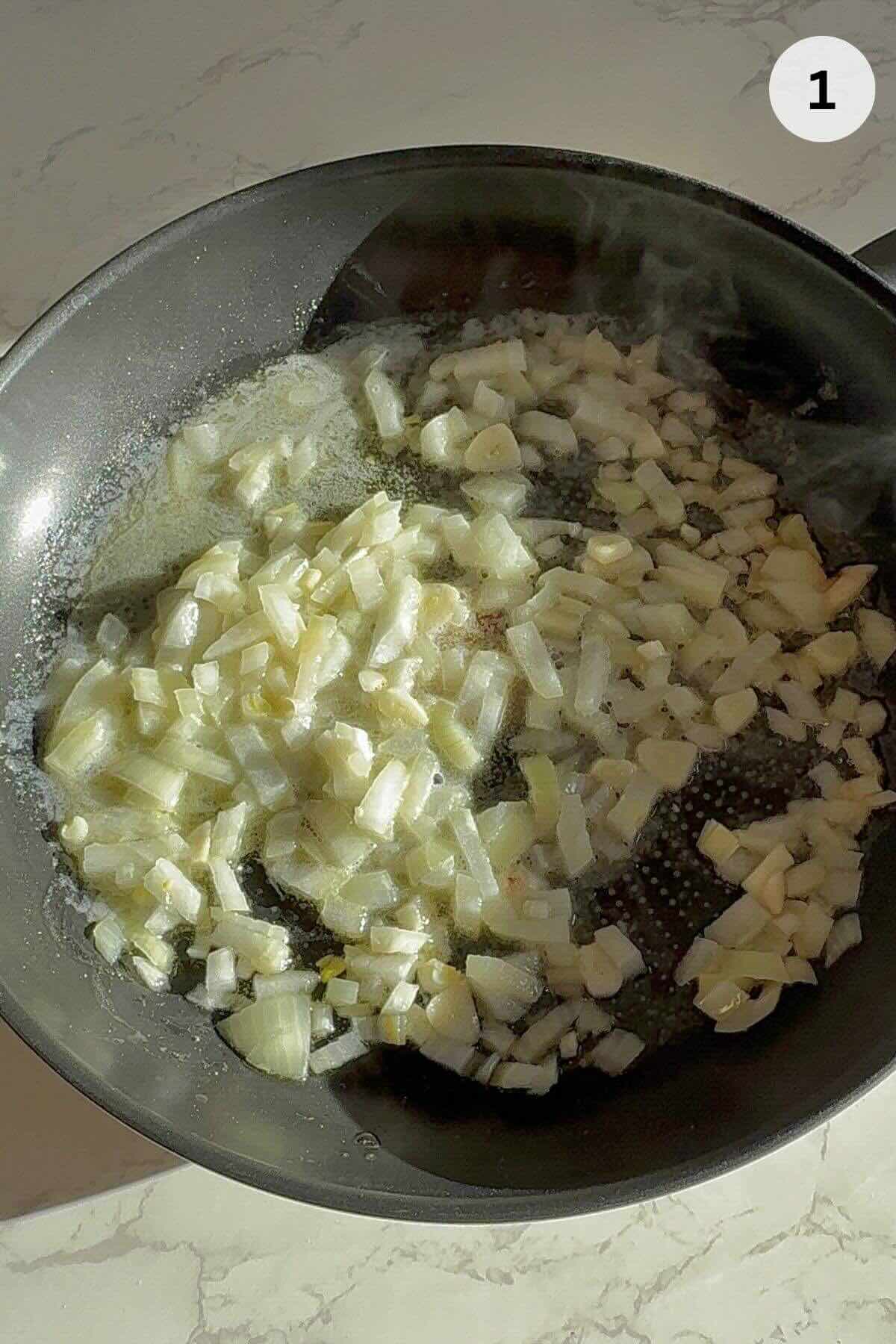 Sautéing onions and garlic in butter and oil in large skillet for mushroom pâté.