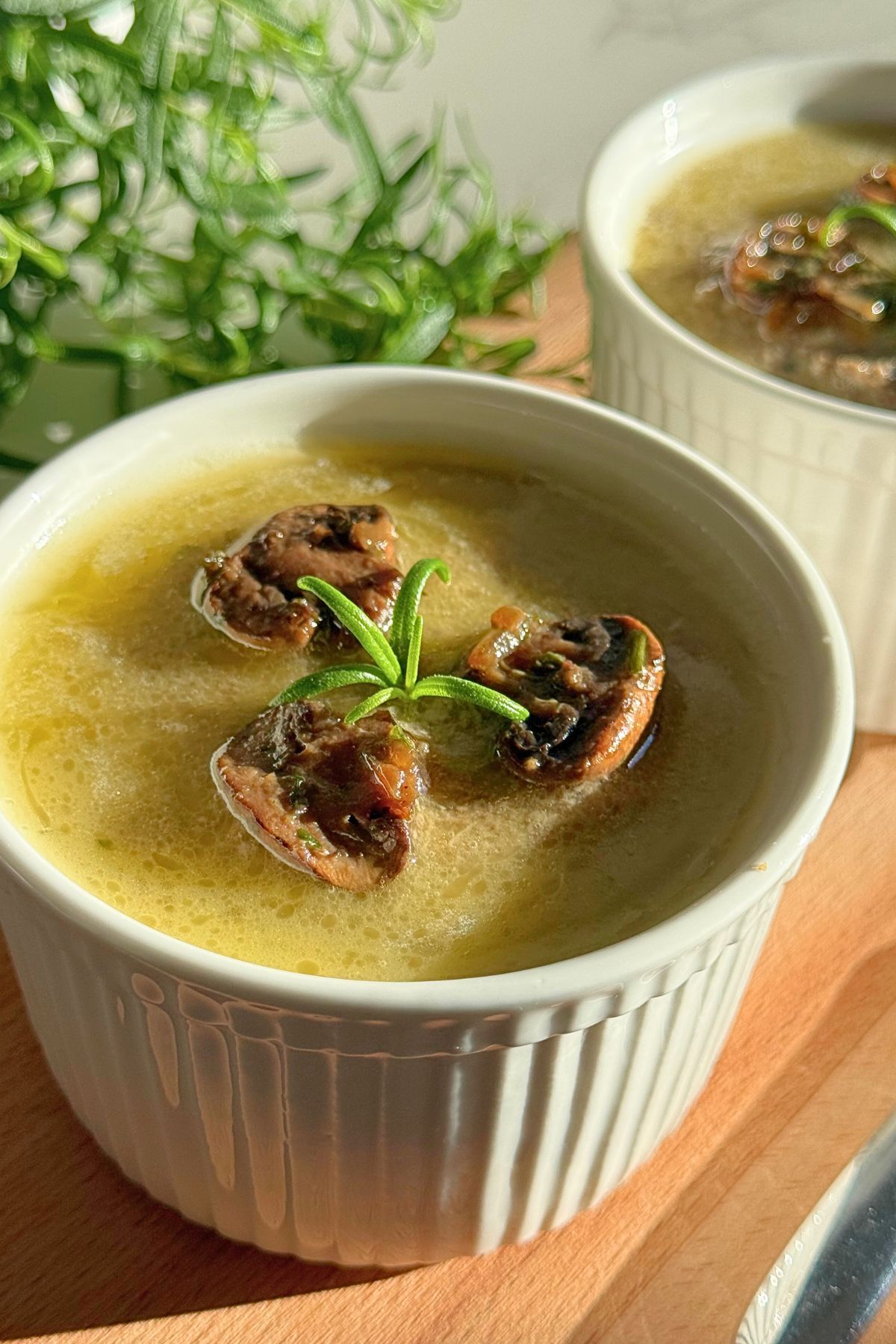 Homemade mushroom paté in a serving dish, topped with mushrooms and rosemary.