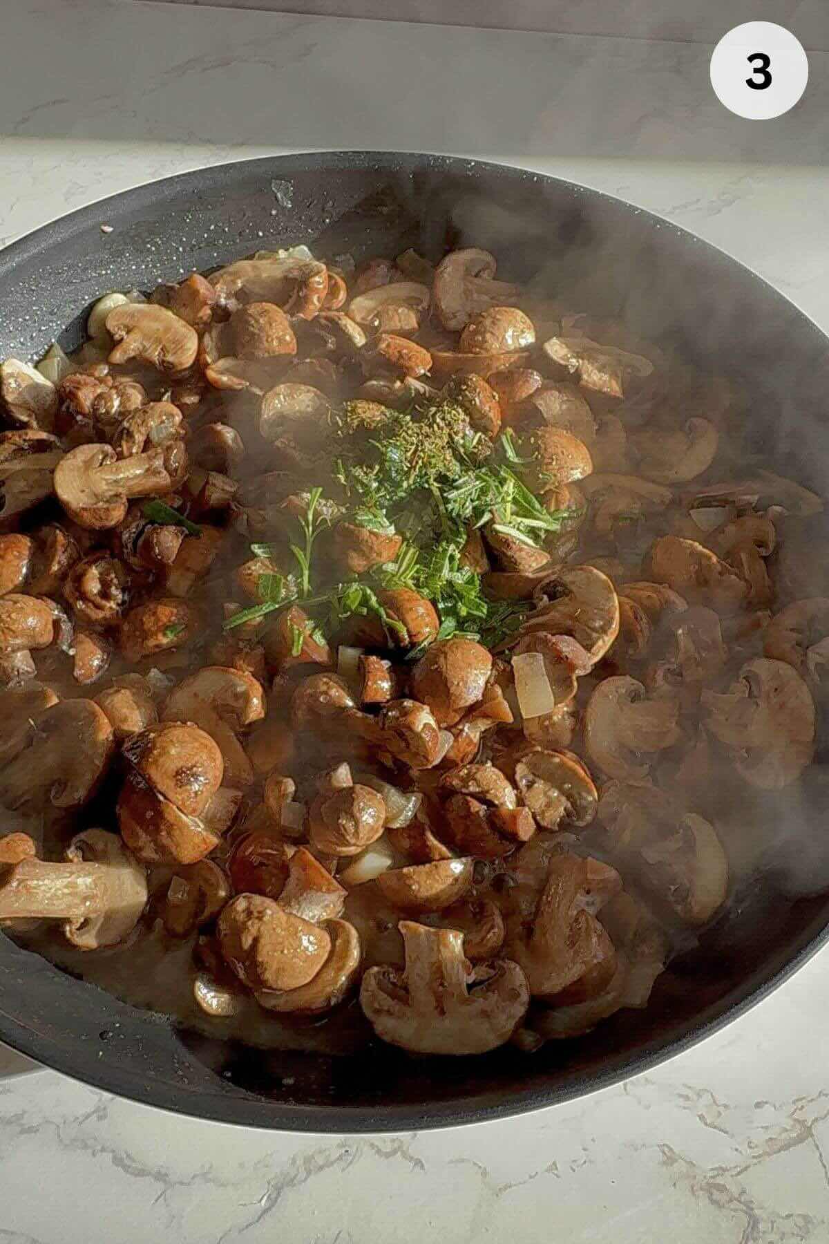 Mushrooms in a pan with salt, pepper, herbs, and soy sauce being stirred.