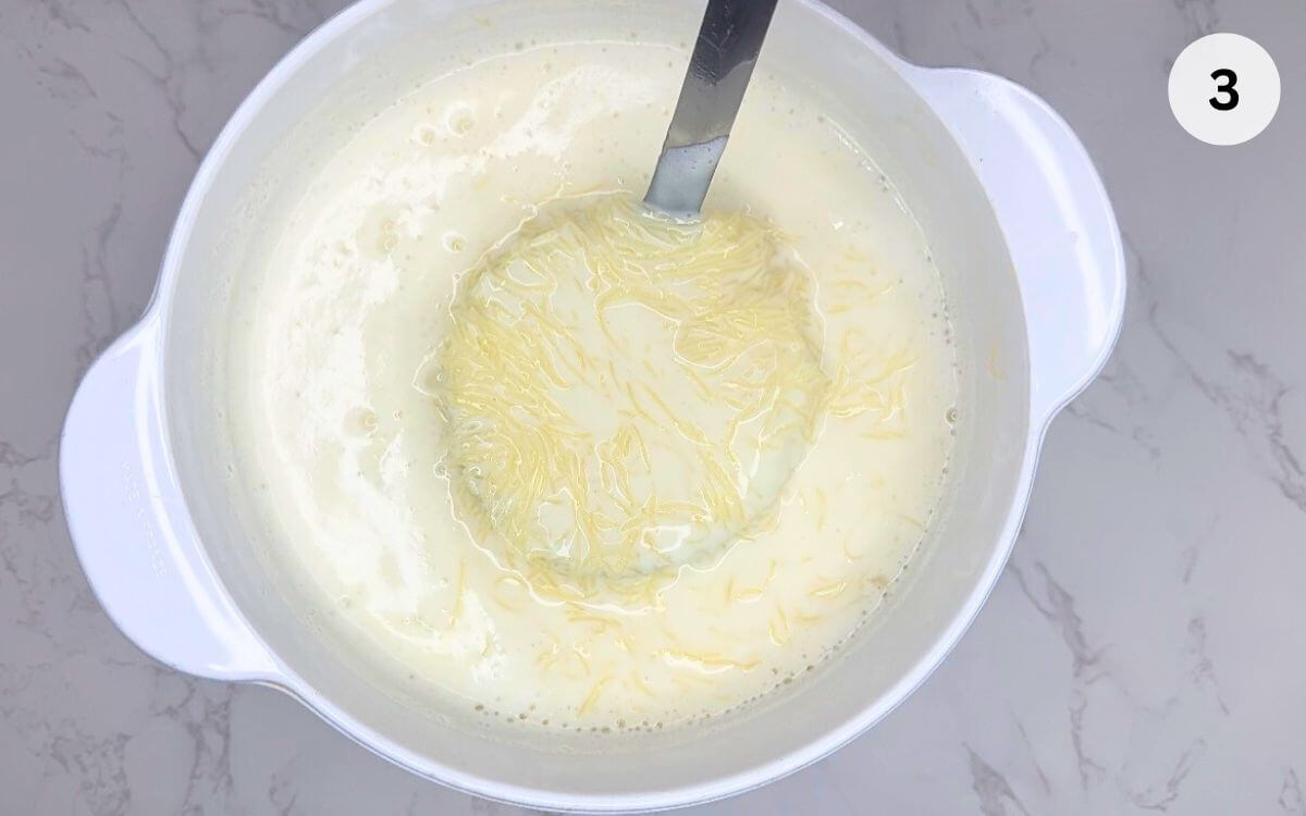 Pan removed from heat with sugar and orange zest added to sweet milk vermicelli.
