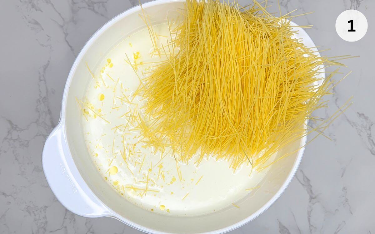 Milk heating in saucepan on stove, being stirred to prevent skin forming on top.