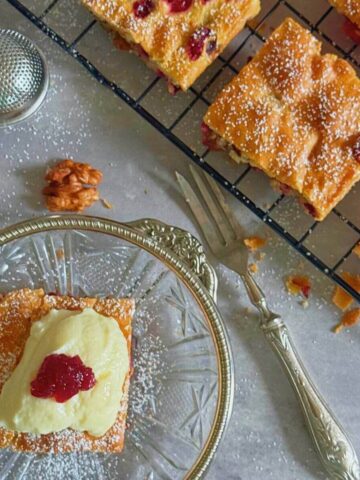Sweet-tart cranberry pecan squares with custard on side.