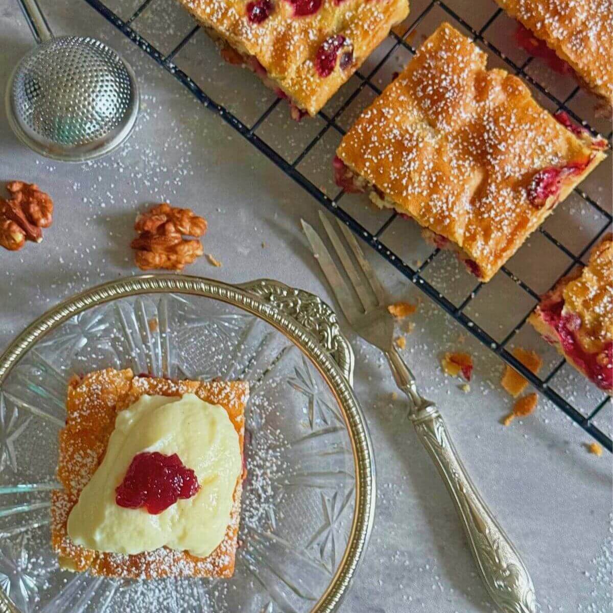 Sweet-tart cranberry pecan squares with custard on side.