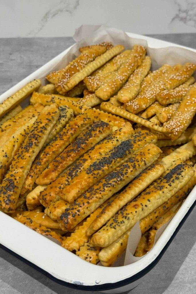 Cheese sticks (saratele) golden, crisp, and lightly puffed on a tray.