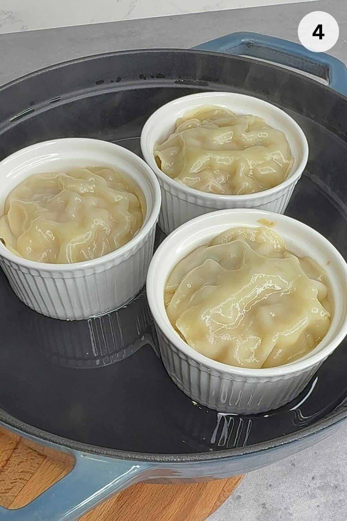 Ramekins placed in covered pot, steaming for 20 minutes until dumplings are fully cooked through.