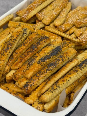 Cheese sticks (saratele) golden, crisp, and lightly puffed on a tray.