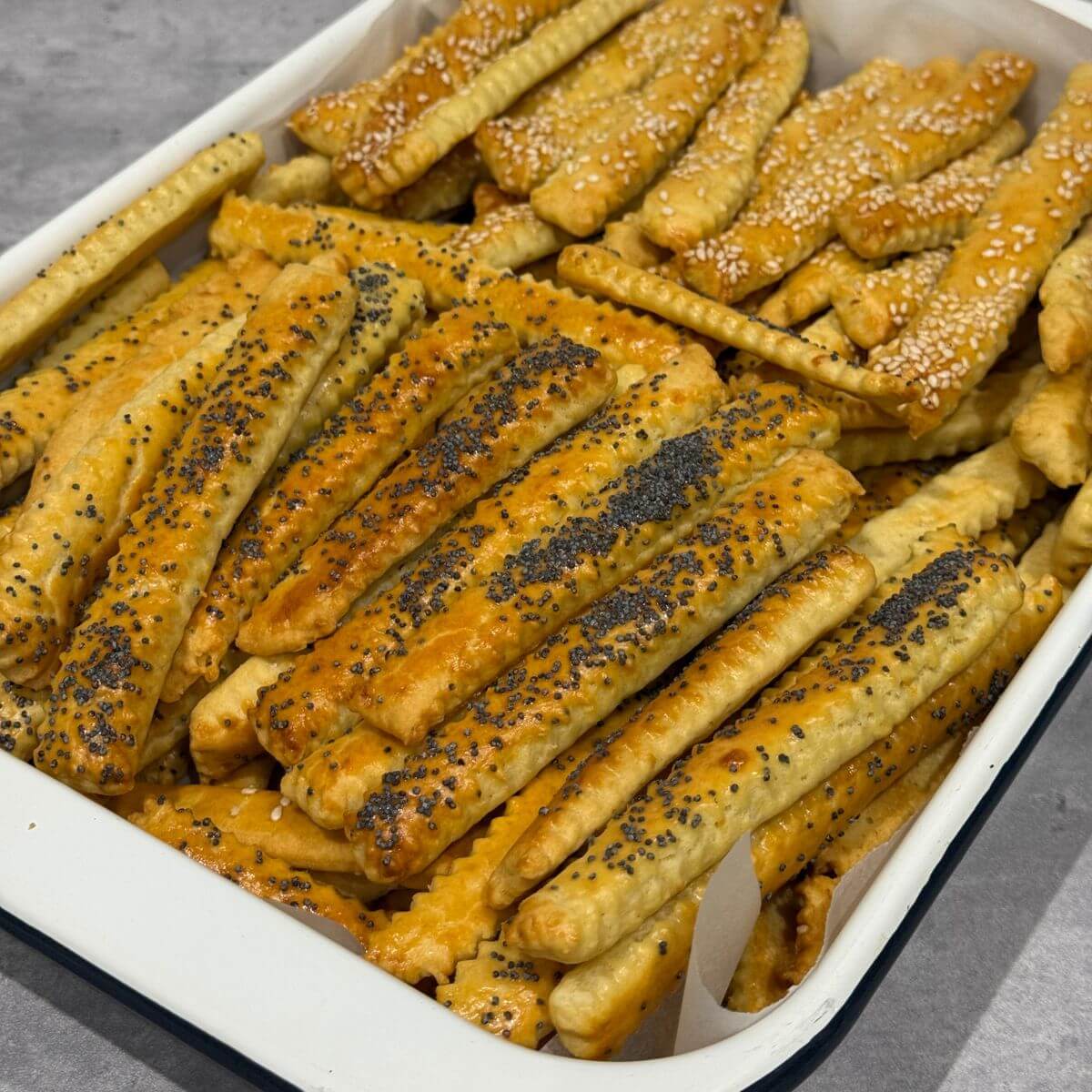 Cheese sticks (saratele) golden, crisp, and lightly puffed on a tray.