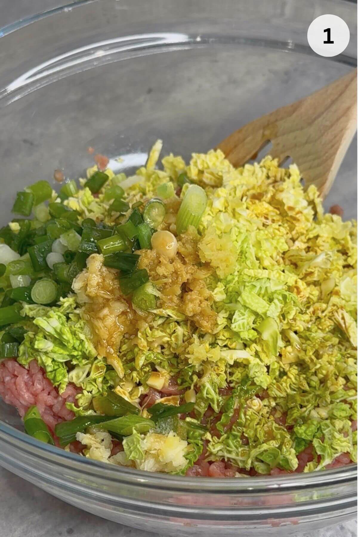 Ground meat, chopped vegetables, and liquid seasonings combined together in a large mixing bowl.