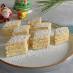Romanian lemon cream cake with four pastry layers and custard filling.