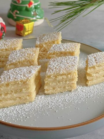 Romanian lemon cream cake with four pastry layers and custard filling.