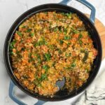 A large skillet filled with a hearty Cabbage Roll Casserole made with ground beef and rice.