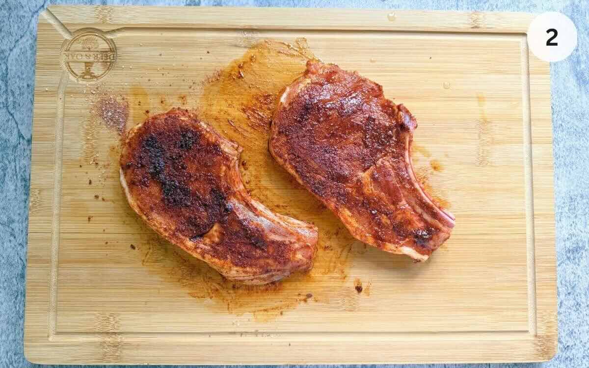 Thick bone-in pork chops coated in olive oil and brown sugar spice rub.