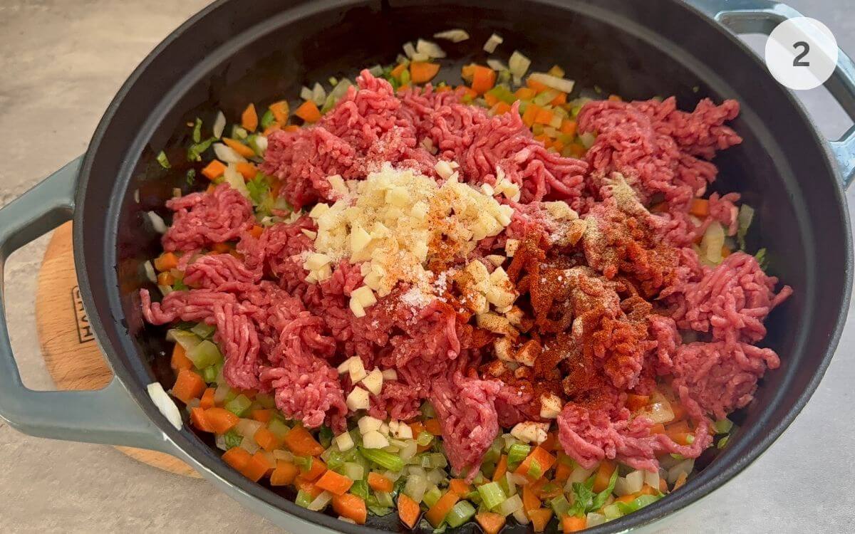 Ground beef and garlic added to the skillet for browning.