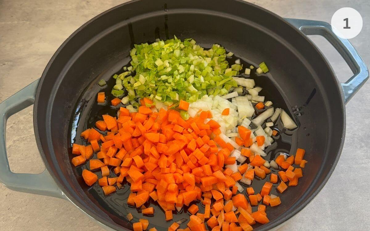 Diced onions, carrots, and celery cooking in a pan with olive oil.