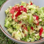 Crunchy broccoli apple salad with honey mustard dressing in a bowl.