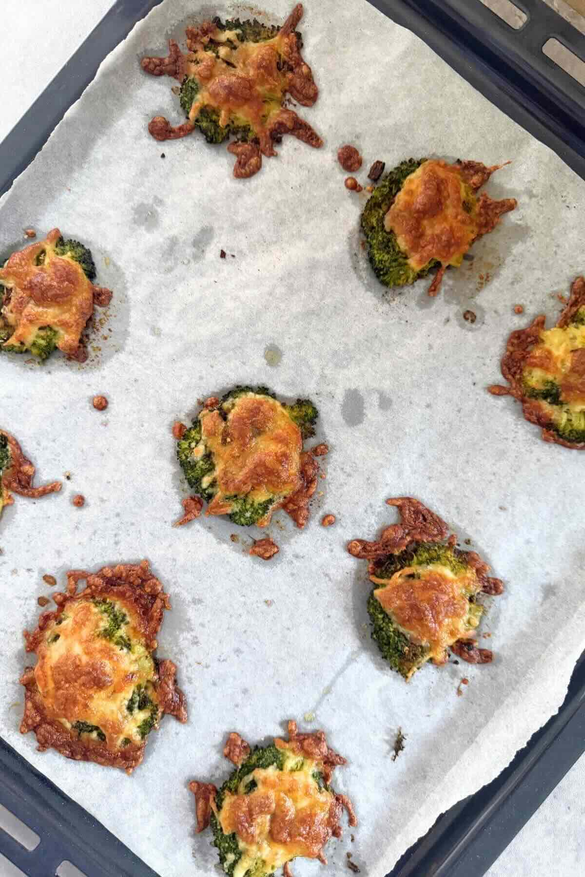 Golden brown crispy smashed broccoli with melted parmesan cheese and charred edges fresh from the oven.