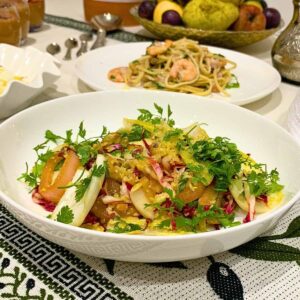 Chicory salad ingredients laid out on marble with clementines pomegranate and fresh chervil.
