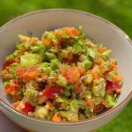 Crunchy broccoli apple salad with honey mustard dressing in a white bowl.