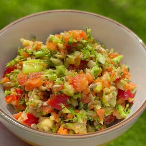 Crunchy broccoli apple salad with honey mustard dressing in a white bowl.