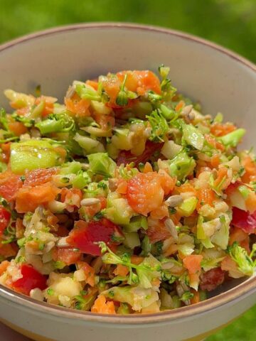 Crunchy broccoli apple salad with honey mustard dressing in a white bowl.