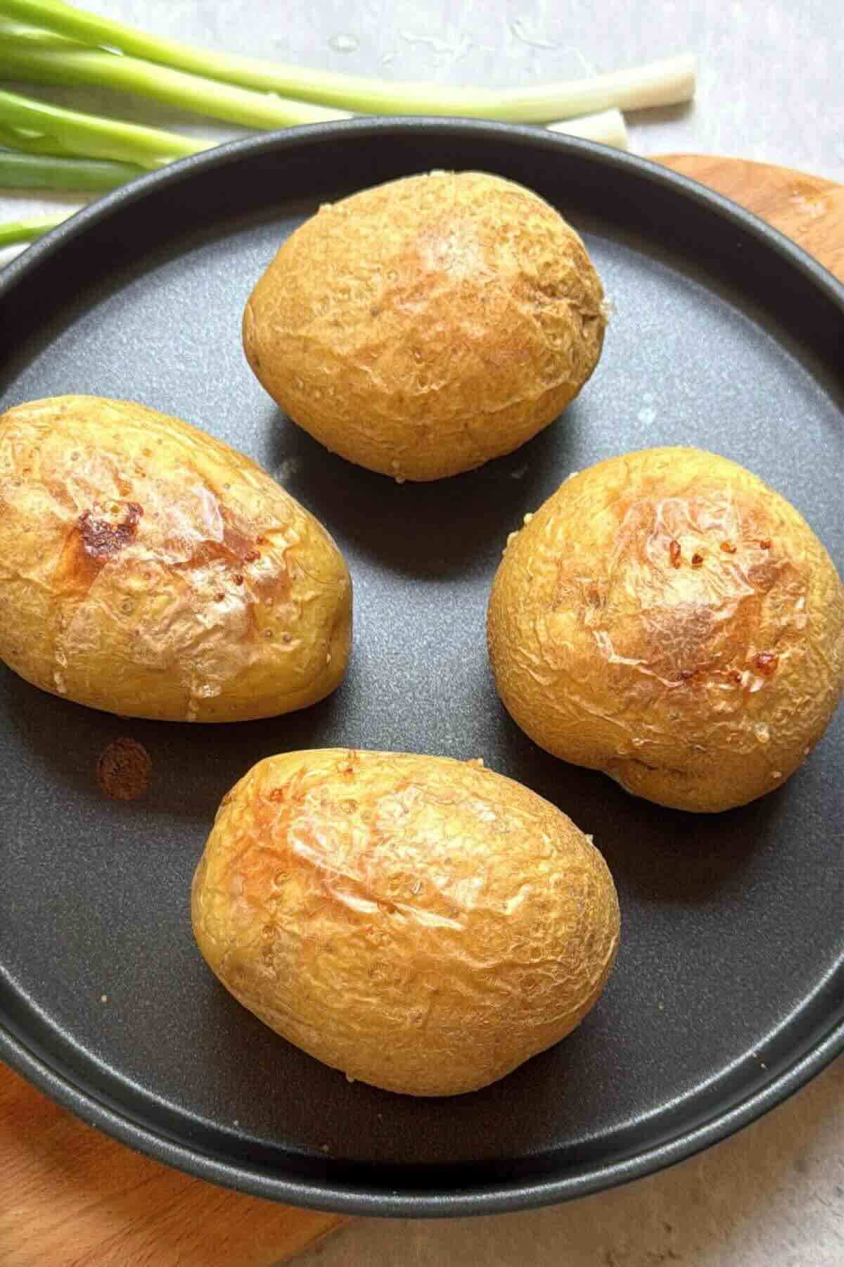 Whole baked potatoes with crisp skins before topping with shrimp.