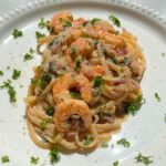 Shrimp linguine with lemon garlic butter plated with parsley garnish.